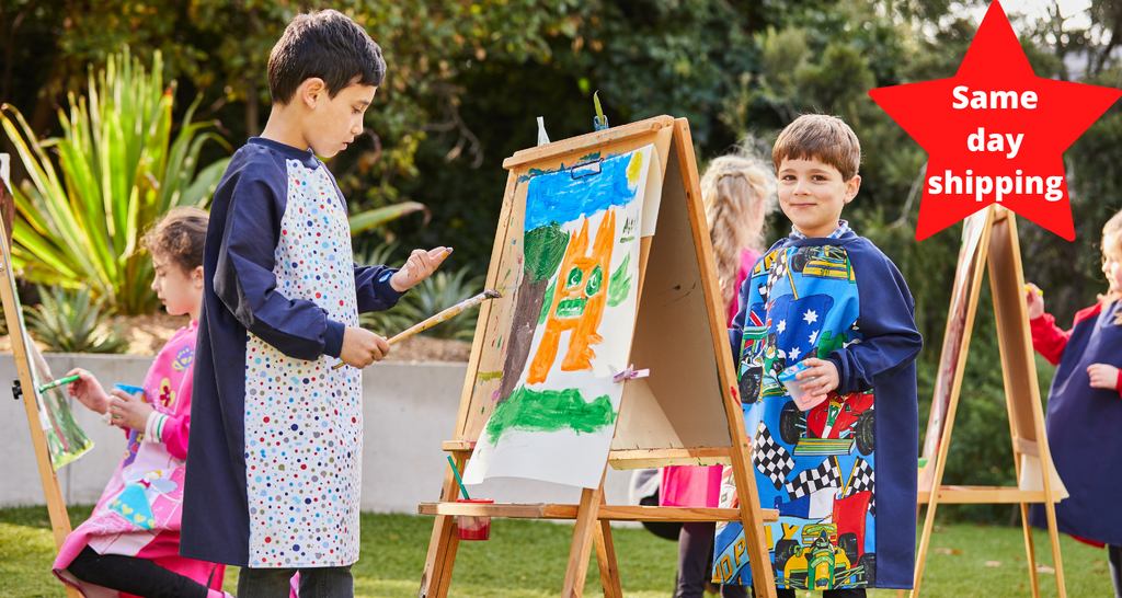 children wearing art smocks and painting at easels: feature 'same day shipping' 